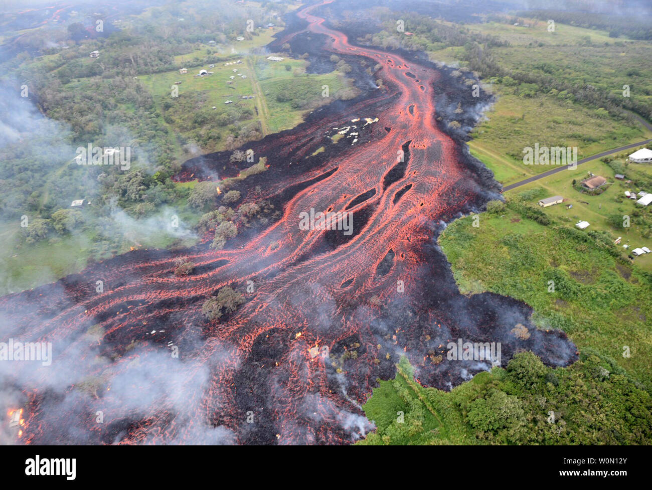 Survol en hélicoptère de Kilauea Volcano zone de rift du Lower East le 19 mai 2018, montrant les coulées de lave émergeant de la scissure forme allongée 16-20 satellite. La direction de l'écoulement dans cette photo est à partir de la région de centre à l'angle inférieur gauche. Un niveau modéré de lave éruption continue le long de l'extrémité nord-est de la fissure active système. En conséquence, les émissions de gaz volcanique ont triplé, passant de 20 fissures résultant en des à des niveaux de dioxyde de soufre dans l'ensemble de la zone sous le vent de l'air. Photo par USGS/UPI Banque D'Images