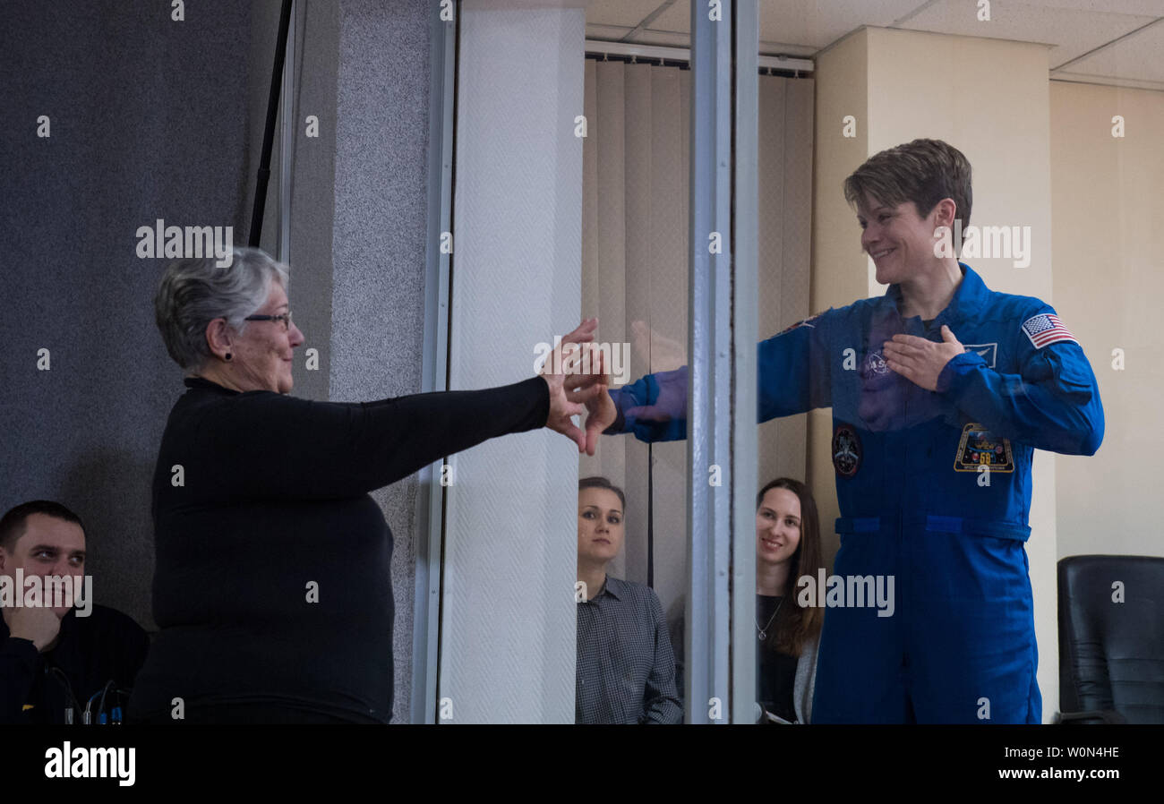 L'ingénieur de vol de l'expédition 58 Anne McClain de la NASA, qui est en quarantaine, met sa main jusqu'à la vitre pour rencontrer sa mère à l'issue d'une conférence de presse, le 2 décembre 2018, à l'hôtel cosmonaute à Baïkonour, au Kazakhstan. Lancement de la fusée Soyouz est prévue pour le 3 décembre qui emportera McClain, commandant de Soyouz Oleg Kononenko de Roscosmos, David Saint-Jacques et ingénieur de vol de l'Agence spatiale canadienne (ASC) en orbite pour servir pendant six mois et demi de mission sur la Station spatiale internationale. Photo de la NASA par Aubrey Gemignani/UPI Banque D'Images