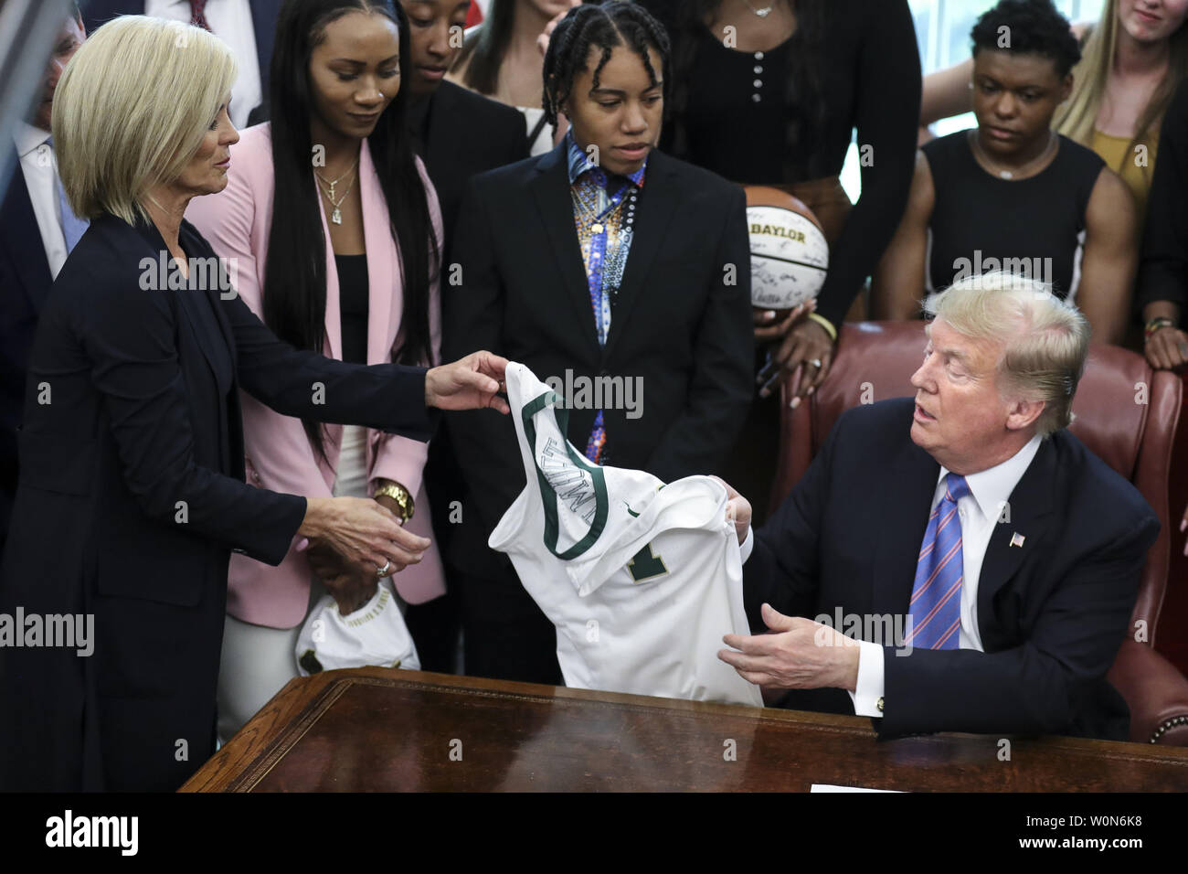 Le président Donald Trump reçoit un maillot de basket-ball avec son nom de l'entraîneur-chef Kim Mulkey comme il se félicite de la 2019 NCAA Division I Women's Basketball Champions nationaux la Dame Baylor Ours dans le bureau ovale de la Maison Blanche le 29 avril 2019 à Washington, DC. Photo par Oliver Contreras/UPI Banque D'Images