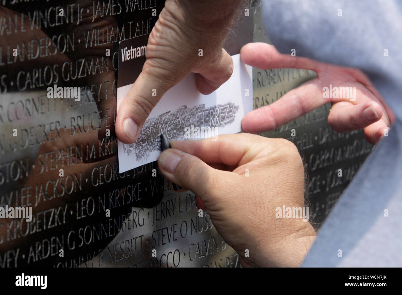 Un visiteurs exploite un crayon traçage d'un nom sur la Vietnam Veterans Memorial à Washington, le 27 mai 2007. Cette année est le 25e anniversaire du monument qui commémore les 58 249 soldats américains et les femmes qui sont morts ou ont été perdus pendant le conflit du Vietnam à partir de 1959-1975. (Photo d'UPI / Kamenko Pajic) Banque D'Images