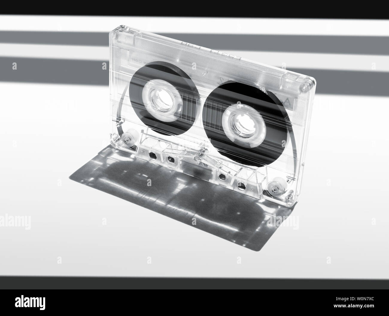 En plastique transparent C90 cassette compact audio tape jette une ombre sur un fond blanc. Banque D'Images