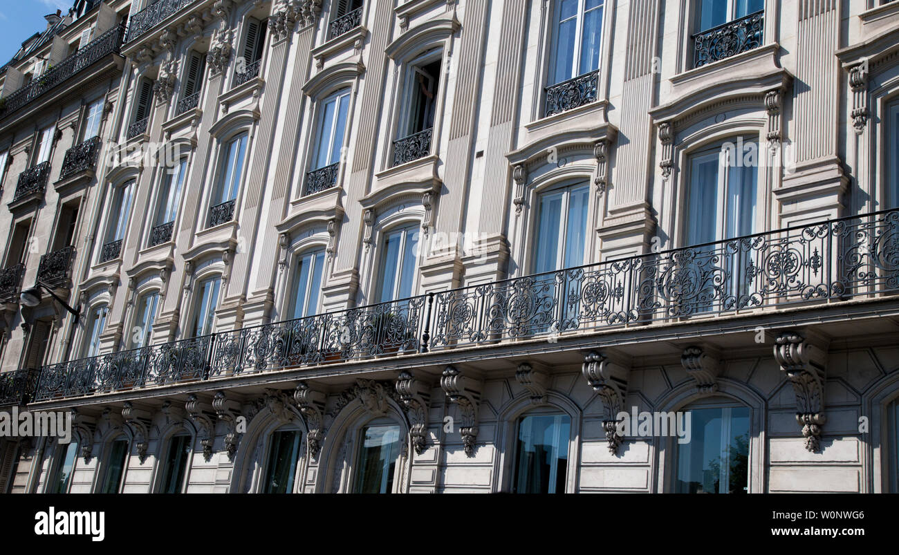 Des fenêtres ornées de Paris France montrant les garde-corps en ferronnerie soutenu par le parapet de balustrades ornementales sur un balcon Banque D'Images