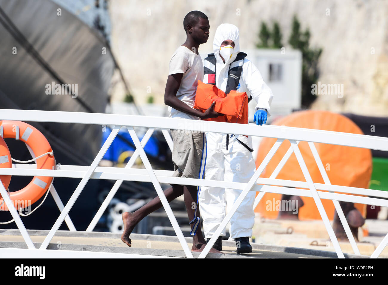 Floriana, Malte. 27 Juin, 2019. Un migrant a sauvé (avant) débarque à une des Forces Armées de Malte (AFM) pied en Floriana, Malte, le 27 juin 2019. Un groupe de 66 migrants clandestins ont débarqué à Malte le jeudi. Credit : Jonathan Borg/Xinhua/Alamy Live News Banque D'Images