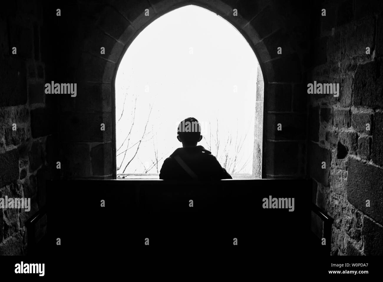 Homme mediatating par la fenêtre du monastère du Mont Saint Michel Banque D'Images