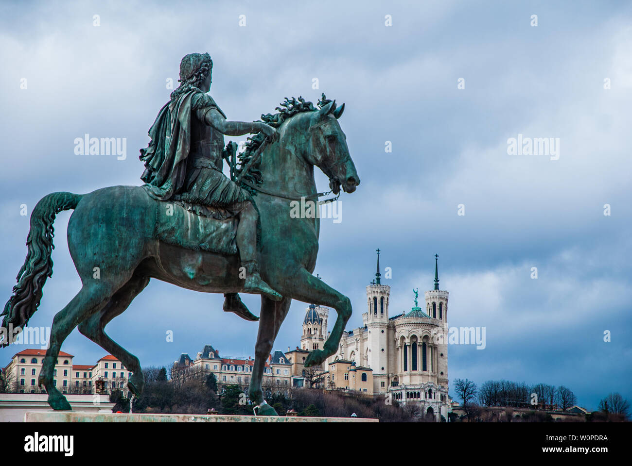 Statue équestre de Louis XIV sur la Place Bellecour avec Basilique Notre Dame de Fourvière en arrière-plan Banque D'Images