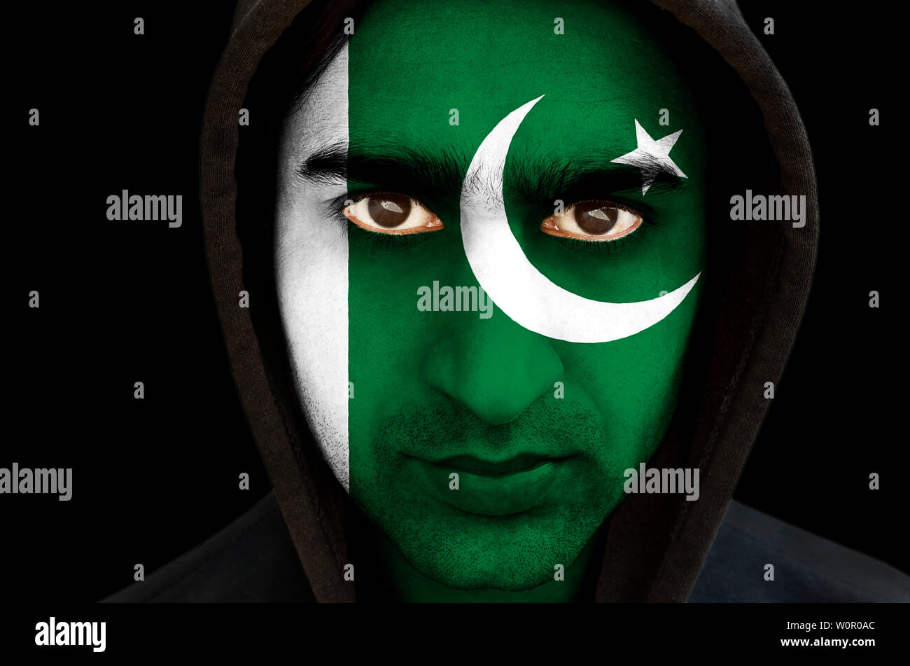 Portrait d'un homme avec un drapeau pakistanais face paint sur fond noir Banque D'Images