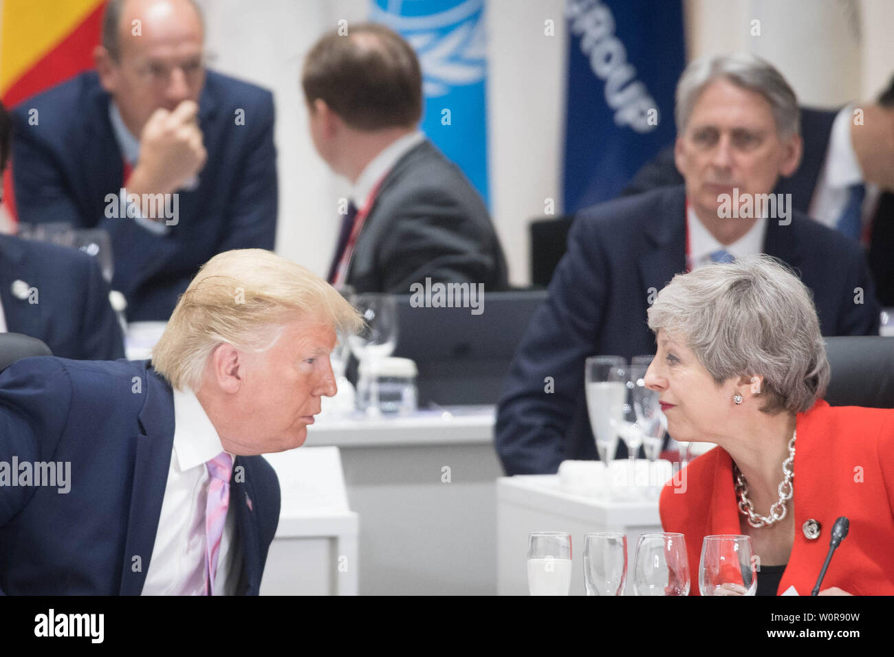 Le président américain, Donald Trump s'entretient avec le Premier ministre britannique Theresa peut, à la première séance de travail du Sommet du G20, à Osaka au Japon. Banque D'Images