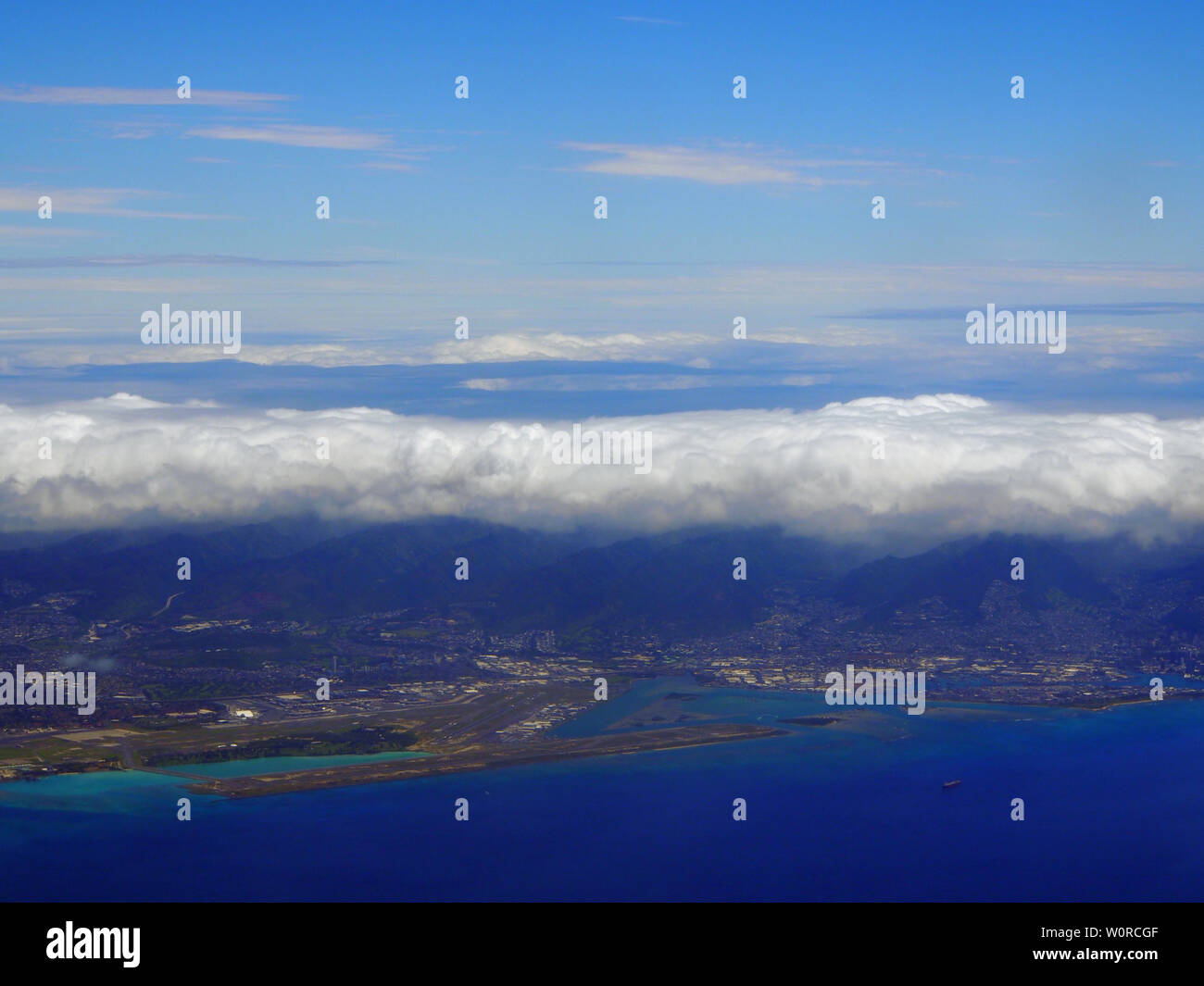 L'Aéroport International d'Honolulu et la piste Corail City vu de l'air avec de l'eau environnante sur Oahu, Hawaii et nuages sur l'île. Porté à l'Ap Banque D'Images