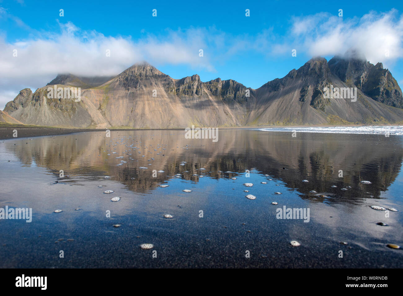 Paysage islandais, reflet de la montagne Vestrahorn dans les eaux de l'océan Atlantique. Péninsule de Stokksnes, Hofn, Islande Banque D'Images