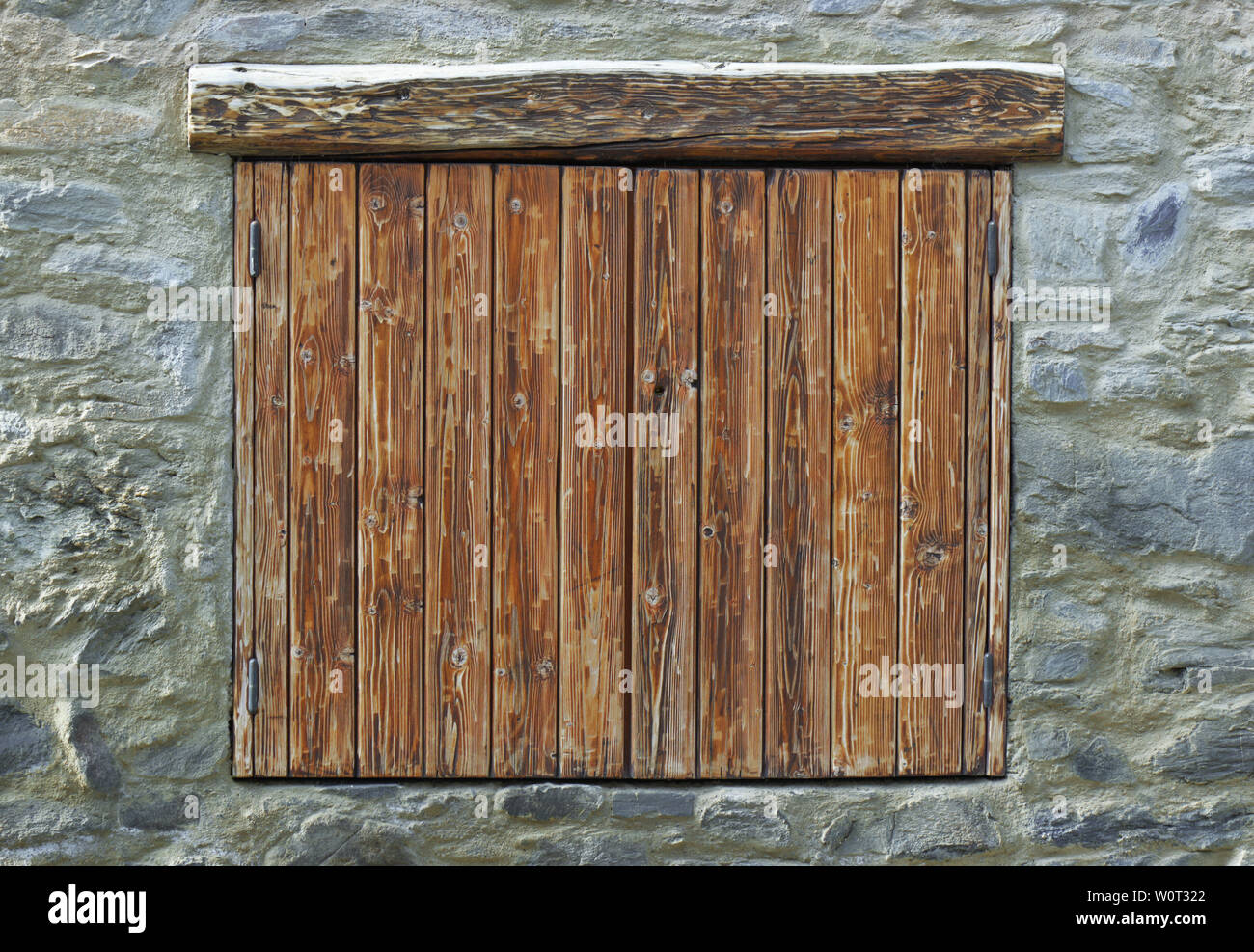Volets en bois, fermé sur une façade en pierre d'un chalet de montagne Banque D'Images