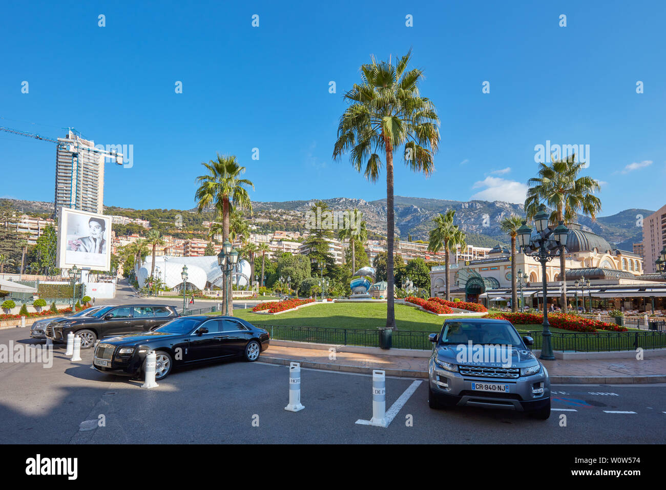 MONTE CARLO, MONACO - le 21 août 2015 : Place du Casino de Monte Carlo avec des voitures de luxe et de palmiers dans une journée ensoleillée à Monaco Banque D'Images