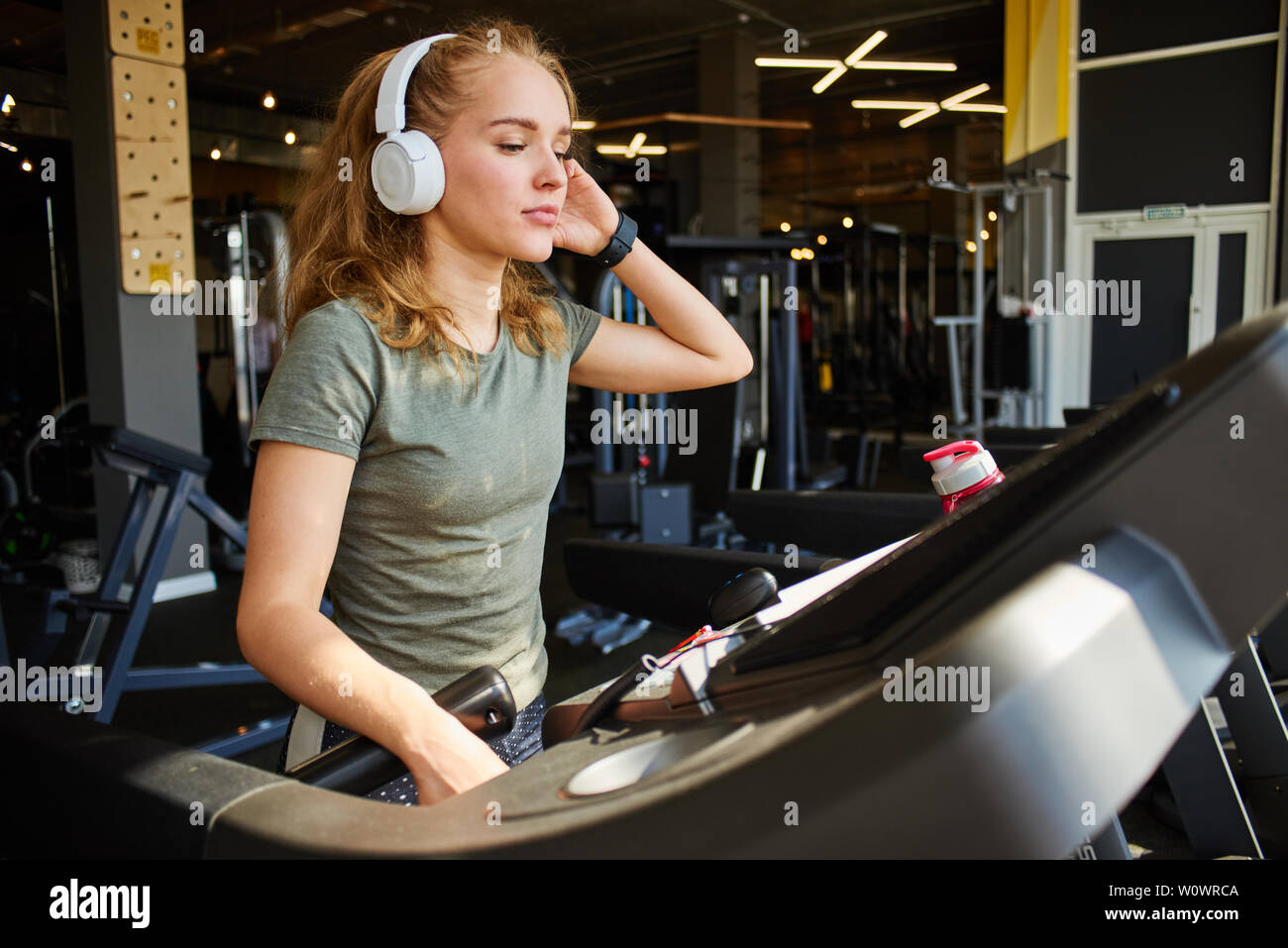 Fille termine la cardio- formation sur le tapis roulant. Banque D'Images