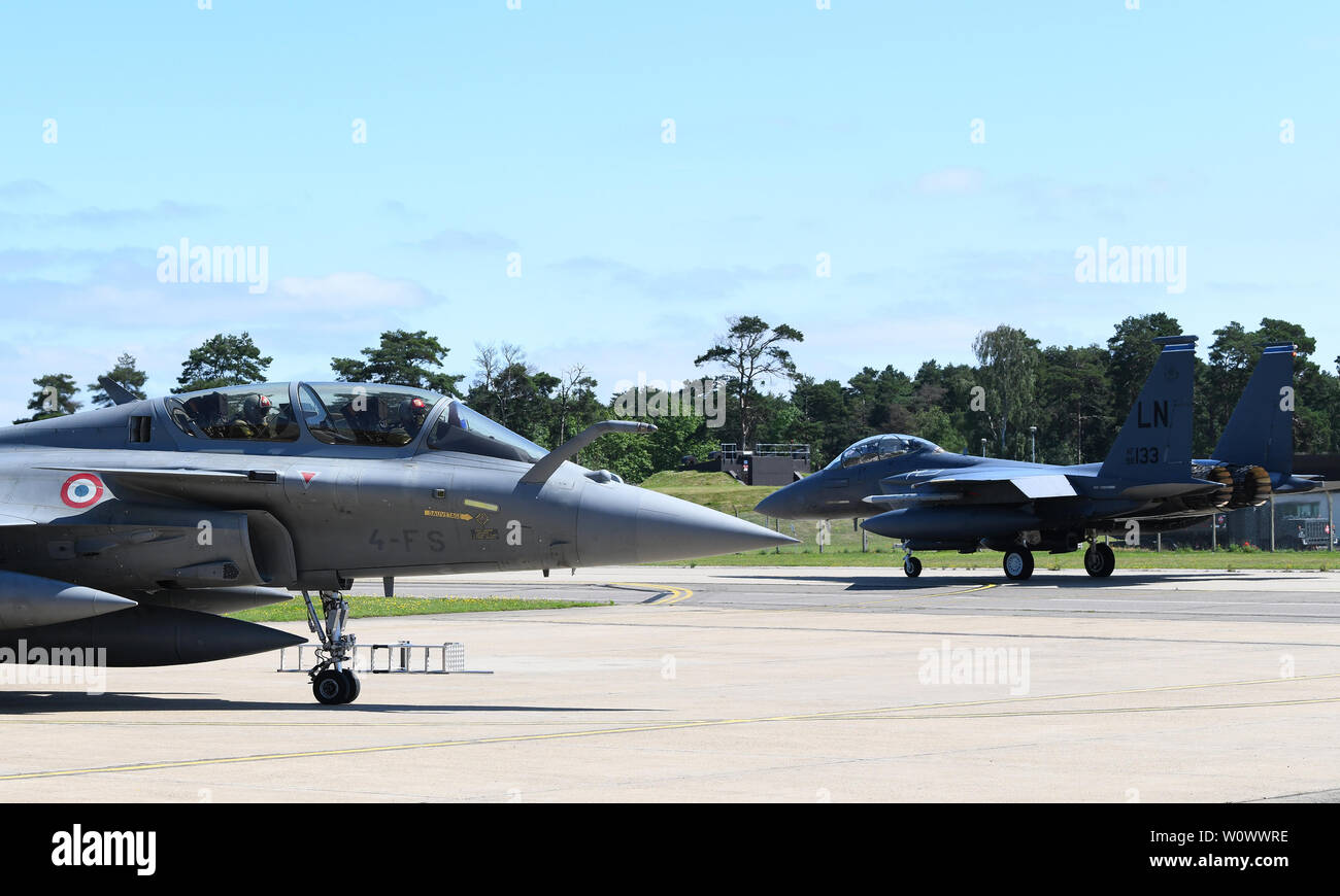 Un F-15E Strike Eagle taxis passé une rafale de l'Armée de l'Air française pendant l'exercice Point Blank 19-2 au Royal Air Force Lakenheath, Angleterre, le 17 juin 2019. Plus de 50 aéronefs de trois nations, les États-Unis, la France et le Royaume-Uni, ont participé à l'exercice en faveur de l'interopérabilité. (U.S. Photo de l'Armée de l'air par le sergent. Alex Fox Echols III/libérés) Banque D'Images