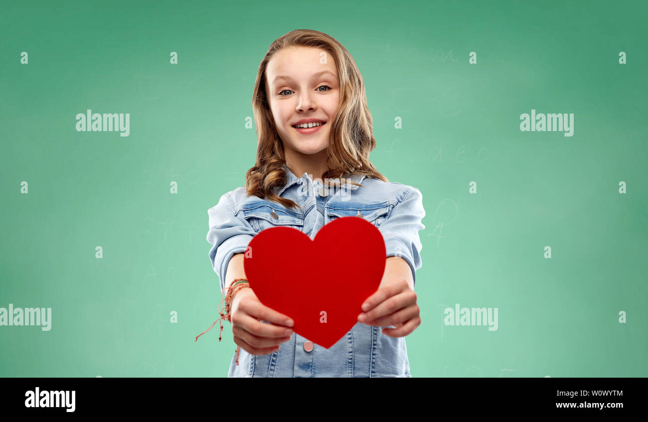 Fille avec coeur rouge au cours de l'école verte tableau Banque D'Images