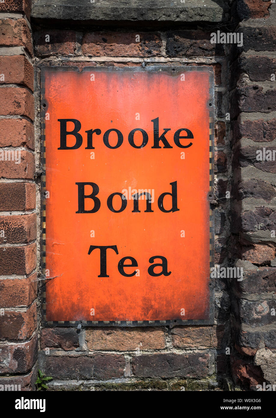 Un vieux millésime signe thé Brooke Bond suspendu à un mur. Banque D'Images