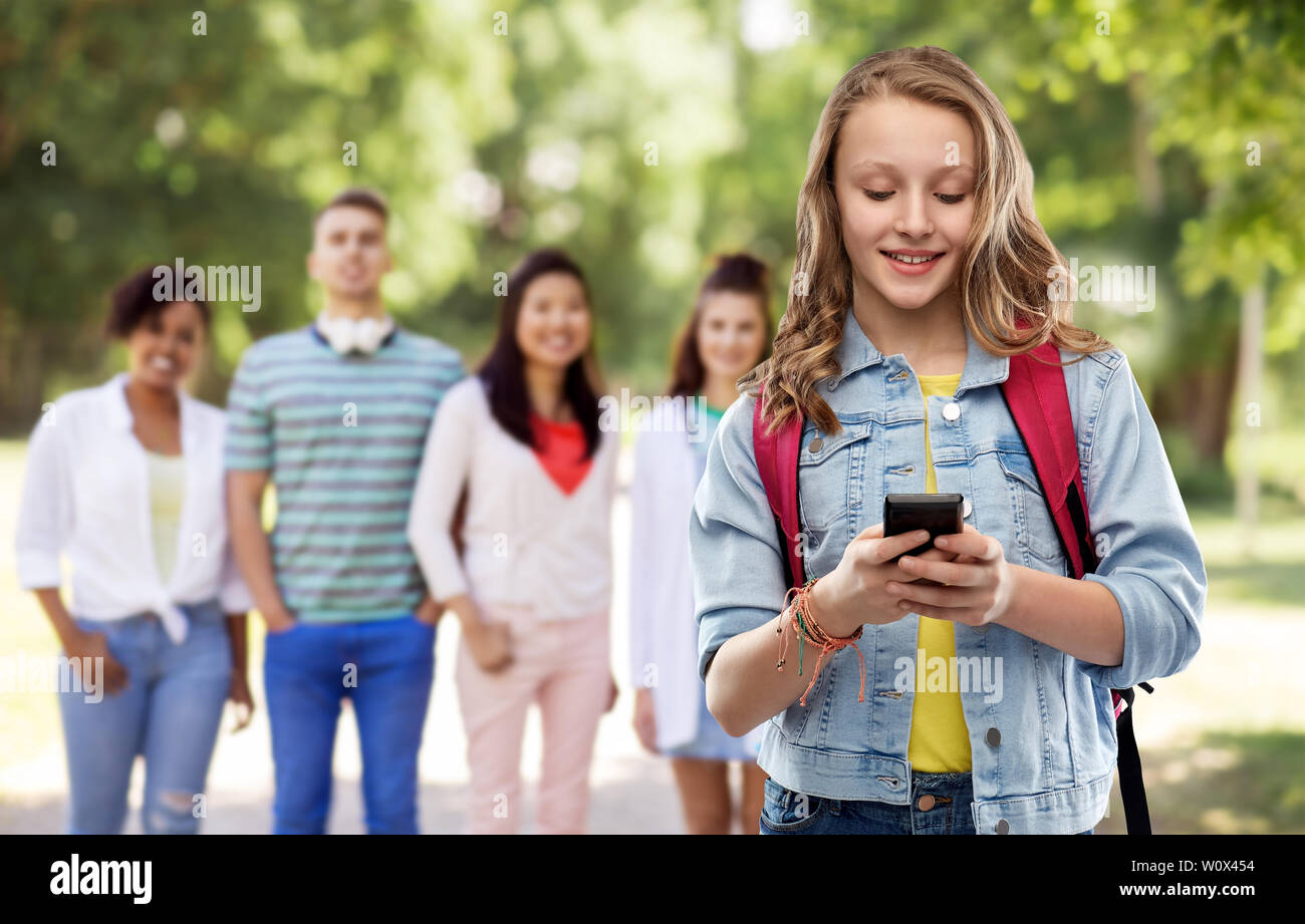Teen girl étudiant avec sac d'école et smartphone Banque D'Images