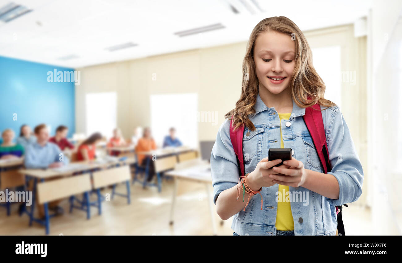 Teen girl étudiant avec sac d'école et smartphone Banque D'Images