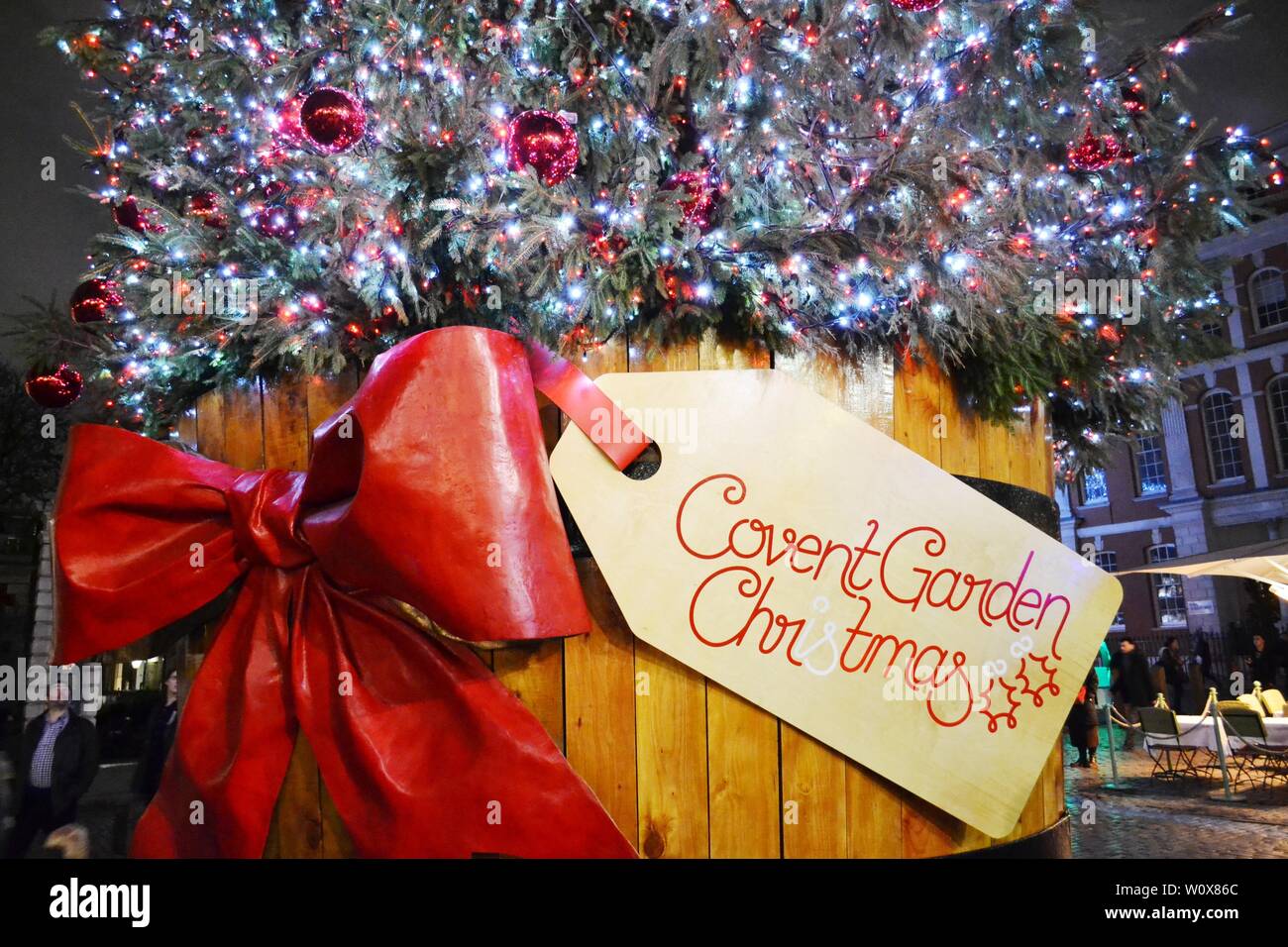 Londres/UK - 27 novembre 2013 : vue d'arbre de Noël traditionnel de la Covent Garden Square dans un tonneau en bois décoré d'arc rouge. Banque D'Images