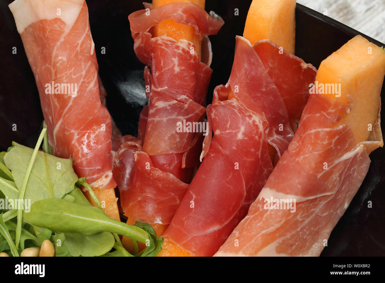 Bâtonnets de Melon enveloppés dans du jambon prosciutto Italien Banque D'Images