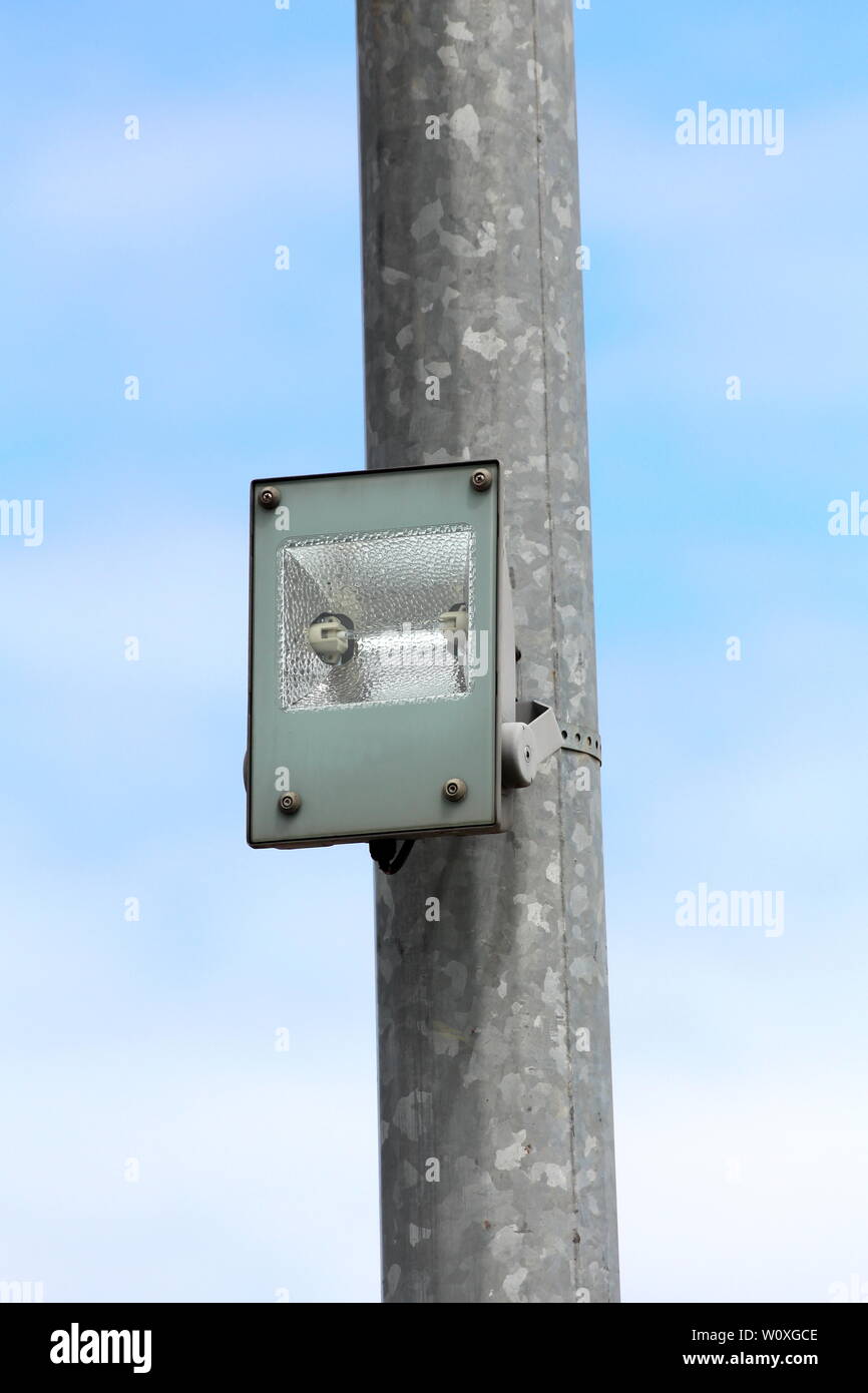 Ancien projecteur extérieur avec lampe halogène monté sur poteau de métal  solide avec ciel nuageux ciel bleu en arrière-plan Photo Stock - Alamy