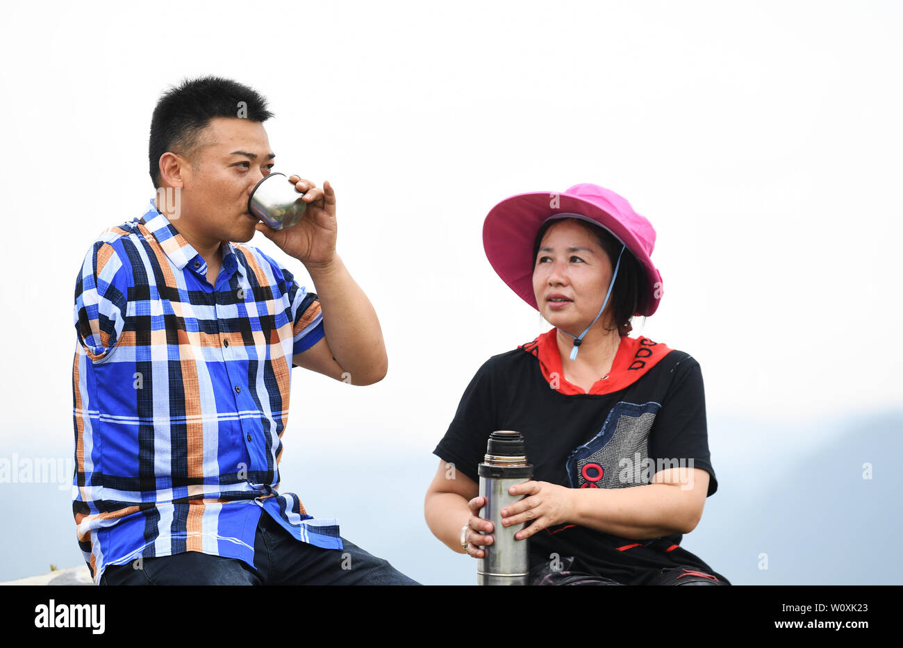 (190628) -- CHONGQING, 28 juin 2019 (Xinhua) -- Liu Yi (L) et son épouse Lu Kai prendre une pause lors d'une plantation de poivre à base Village de Yulong Nanping Ville située dans le district Nanchuan, sud-ouest de la Chine, Chongqing, le 27 juin 2019. Malgré la perte de son bras droit dans un accident à l'âge de neuf ans, 44 ans, Liu Yi n'a jamais baissé la tête vers le destin. Après l'obtention du diplôme d'une école de formation professionnelle en 1994, il a essayé de nombreux emplois comme lave-vaisselle, fruits concessionnaire et mineur de charbon. Depuis 2010, il a décidé de démarrer sa propre entreprise à sa ville natale en organisant les villageois à planter des racines de bambou et raisi Banque D'Images