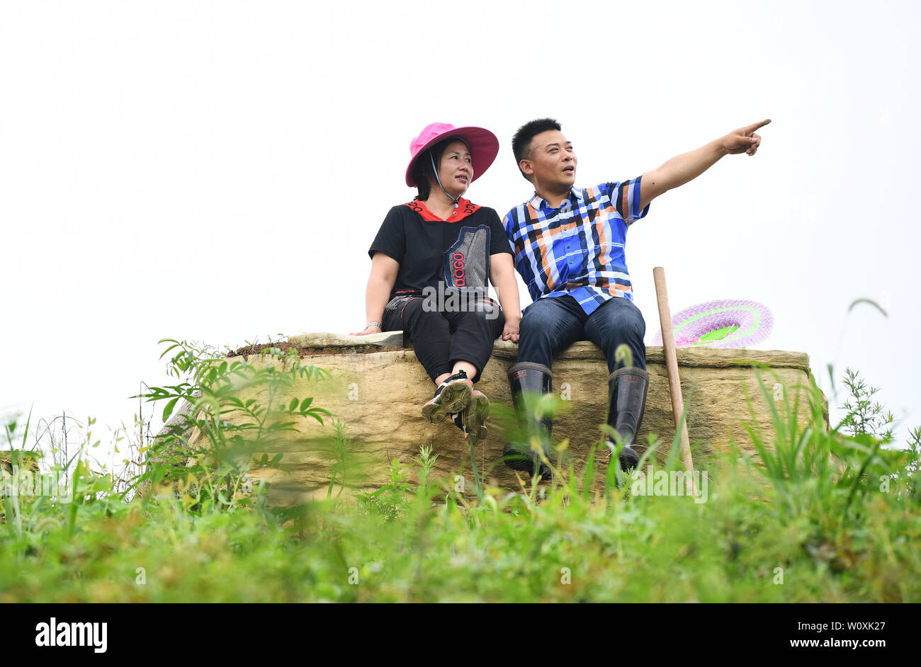 (190628) -- CHONGQING, 28 juin 2019 (Xinhua) -- Liu Yi (R) et son épouse Lu Kai prendre une pause lors d'une plantation de poivre à base Village de Yulong Nanping Ville située dans le district Nanchuan, sud-ouest de la Chine, Chongqing, le 27 juin 2019. Malgré la perte de son bras droit dans un accident à l'âge de neuf ans, 44 ans, Liu Yi n'a jamais baissé la tête vers le destin. Après l'obtention du diplôme d'une école de formation professionnelle en 1994, il a essayé de nombreux emplois comme lave-vaisselle, fruits concessionnaire et mineur de charbon. Depuis 2010, il a décidé de démarrer sa propre entreprise à sa ville natale en organisant les villageois à planter des racines de bambou et raisi Banque D'Images