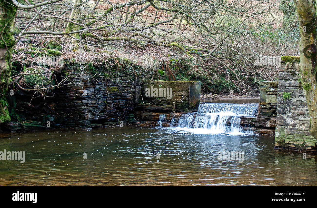 L'eau tombant sur un barrage sur la rivière lliw au Pays de Galles. Entre la partie supérieure et inférieure du réservoir lliw. Afon Lliw, près de Felindre, Swansea, Pays de Galles, Royaume-Uni. Banque D'Images