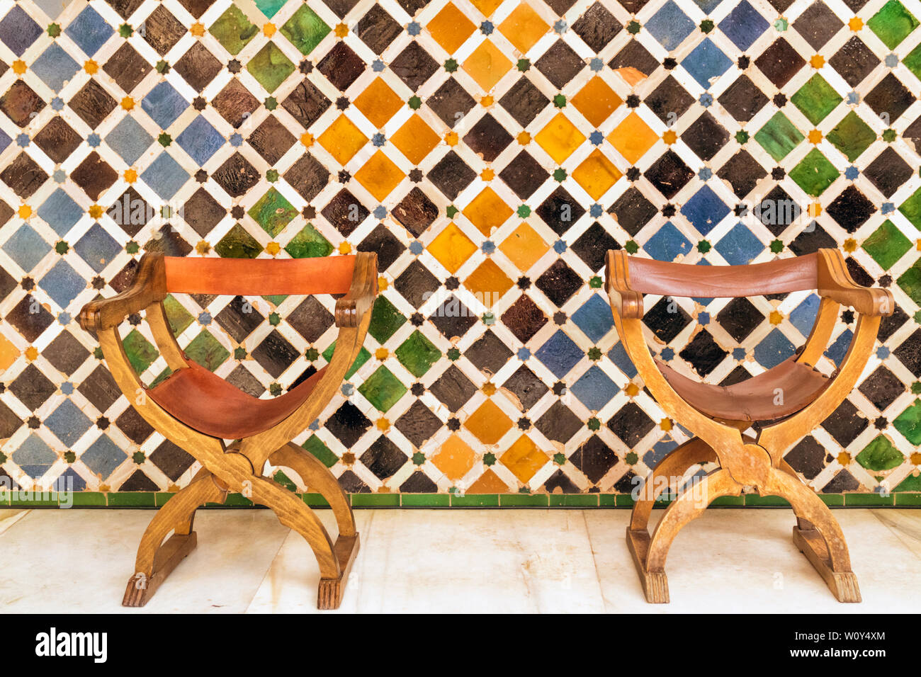 Chaises de style espagnol contre un mur en mosaïque dans la Cour des Myrtes, l'Alhambra, Grenade, Province de Grenade, Andalousie, Espagne du sud. L'un Banque D'Images