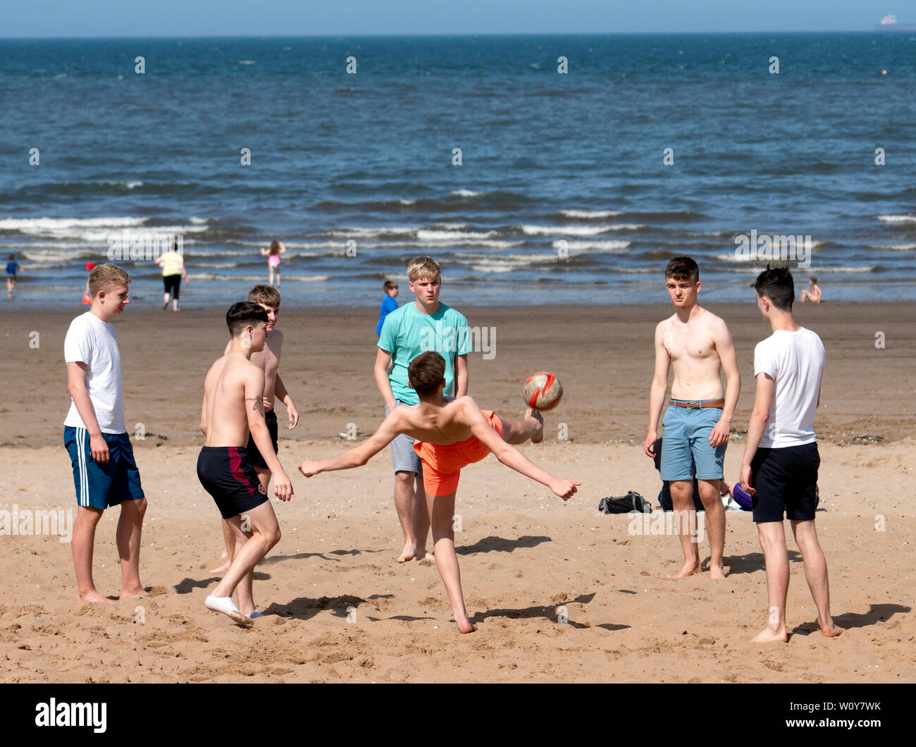 Portobello, Ecosse, Royaume-Uni. 28 Juin, 2019. Les températures chaudes et soleil ininterrompue ont amené des centaines de personnes et les familles à profiter de cette célèbre plage en dehors de Paris. Adolescents jouant au football sur la plage. Credit : Iain Masterton/Alamy Live News Banque D'Images