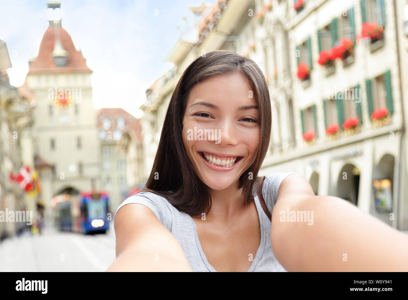 Woman with smart phone selfies à Berne Suisse marche sur Berne Kramgasse, rue principale de la vieille ville. Jeune femme visiter les attractions et sites touristiques. Banque D'Images