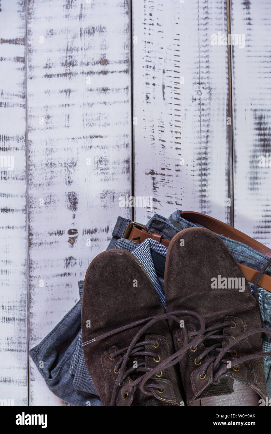 Jean robe avec ceinture brune,polo gris et marron chaussures sur une table en bois blanc Banque D'Images