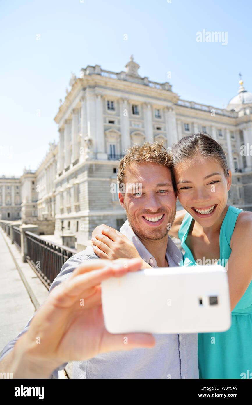 Couple taking photo selfies sur smartphone à Madrid. L'homme et de la femme romantique dans l'amour à l'aide de smart phone de prendre l'auto-portrait photographique sur le voyage à Madrid, Espagne. Banque D'Images