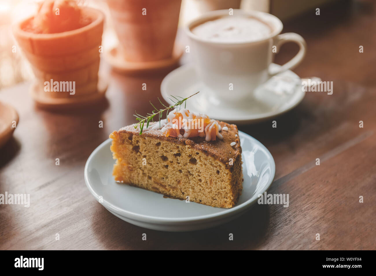 Gâteau de fruit en pause café servent de coupe en plaque blanche avec un éclairage chaleureux. Banque D'Images