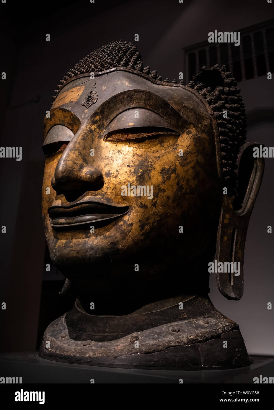 Golden Buddha statue tête de l'art ancien de la Thaïlande de Bangkok avec un faible éclairage et ombre sombre. Banque D'Images