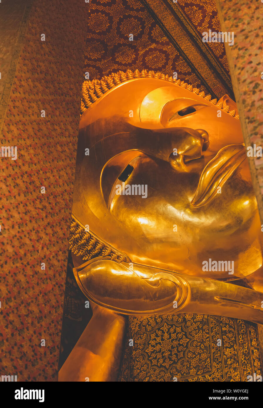 Statue du Bouddha d'or du sommeil de l'art ancien de la Thaïlande de Bangkok avec sun avertir ton gris d'éclairage couleur. Banque D'Images