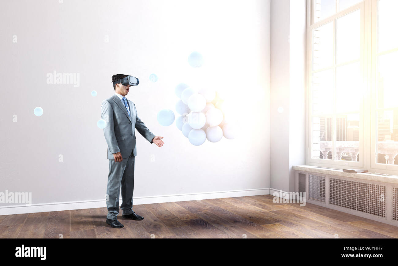 Businessman in VR casque avec abstract tas de domaines. Technique mixte Banque D'Images