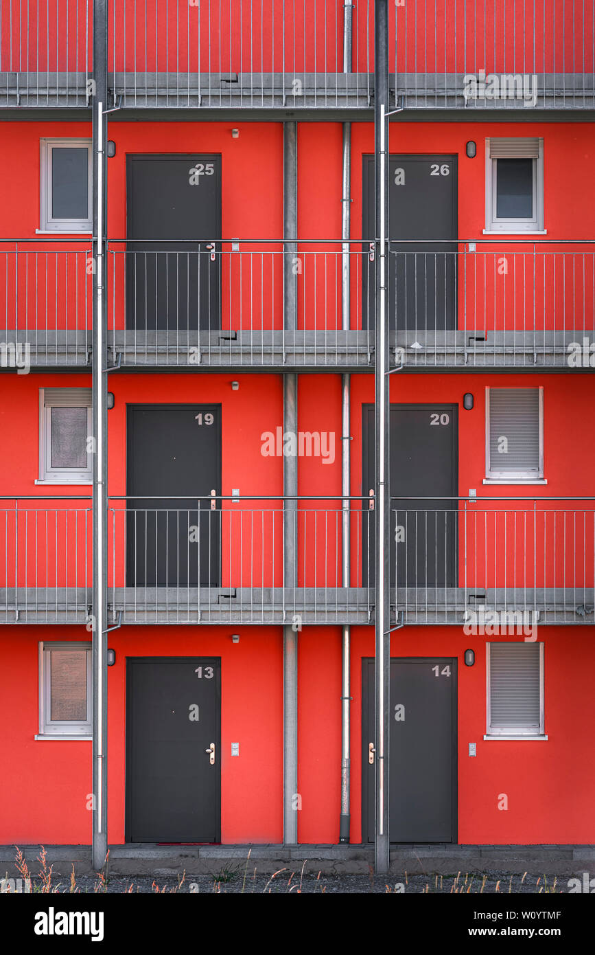 Close-up d'un appartement moderne de la façade de l'immeuble avec des murs rouges et gris, portes à Schwabisch Hall, en Allemagne. Banque D'Images