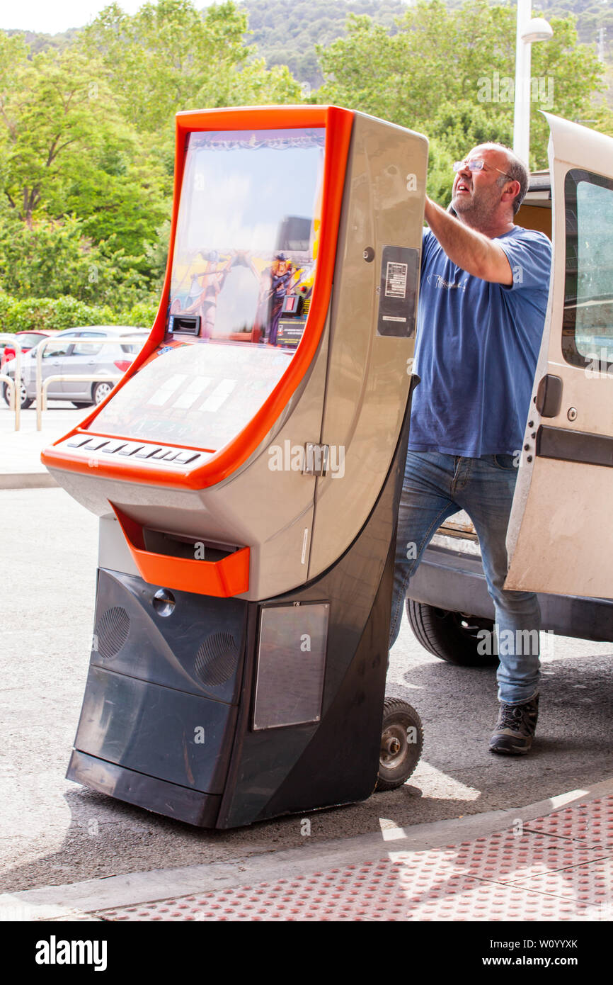 Homme chargeant une machine à sous de jeu dans l'arrière d'une camionnette Banque D'Images