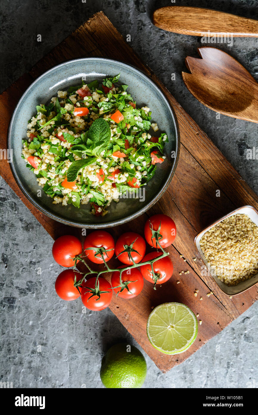 Végétarien salade rafraîchissante taboulé de boulgour, avec le persil, la menthe, les tomates et l'assaisonnement Banque D'Images