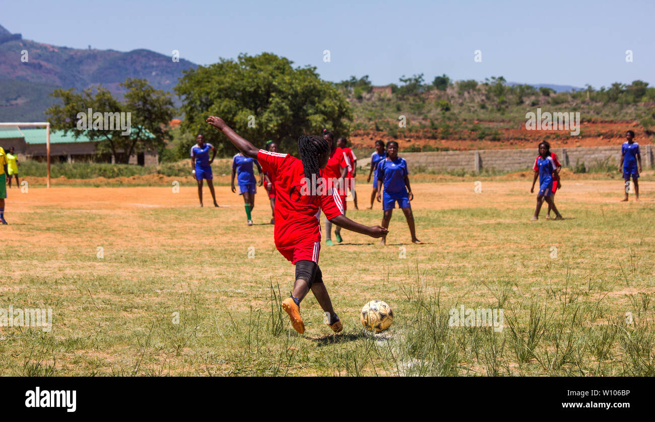 Lycéennes jouant au football dans leur match de classe d'éducation physique Banque D'Images