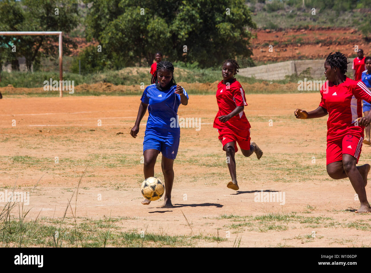 Lycéennes jouant au football dans leur match de classe d'éducation physique Banque D'Images