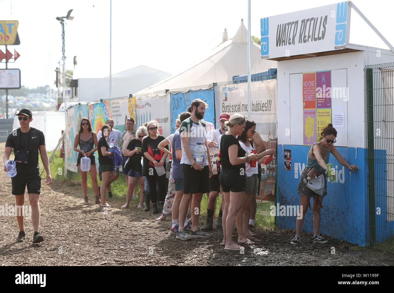 Les festivaliers en attente à un point de remplissage d'eau au festival de Glastonbury, en digne ferme dans Pilton, Somerset. Banque D'Images