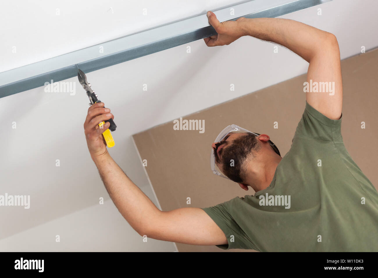 Mur de plâtre bâtiment travailleur. Travailler avec les outils de coupe, de  mesure et de fixation pour cloison sèche Photo Stock - Alamy