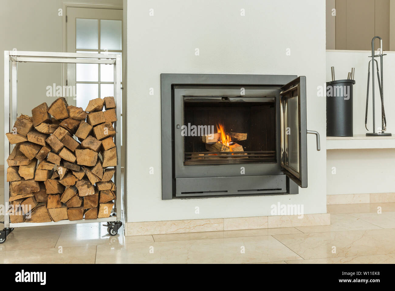 Design moderne et luxueux cheminée bois brûlant, porte avec fenêtre en  verre résistant au feu. Home intérieur avec murs blancs sur fond jaune en  marbre Photo Stock - Alamy