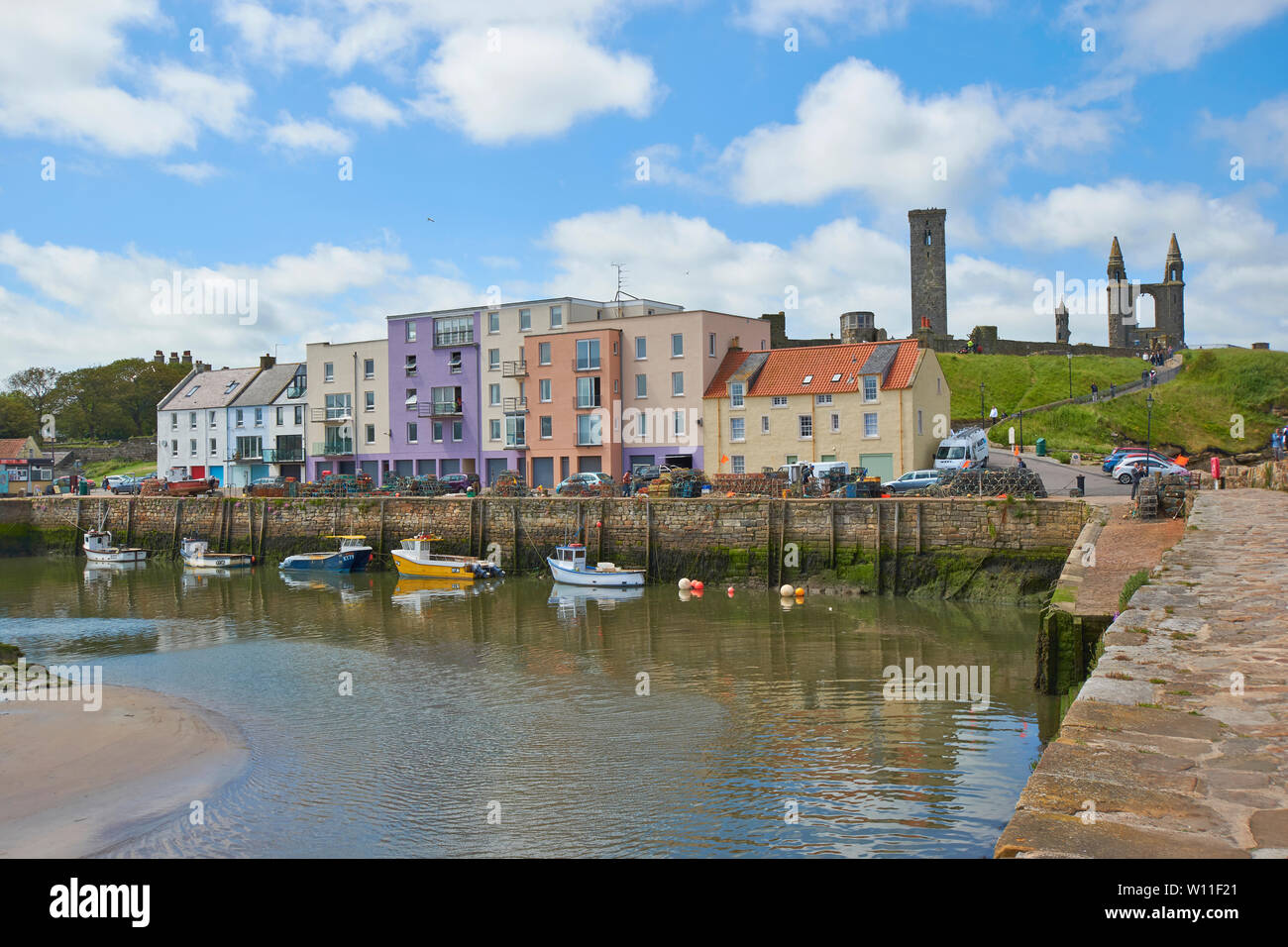 ST ANDREWS FIFE ECOSSE LE QUAI ET MAISONS COLORÉES DONNANT SUR LE PETIT PORT D'ÉTÉ dans les ruines de la CATHÉDRALE DANS LA DISTANCE Banque D'Images