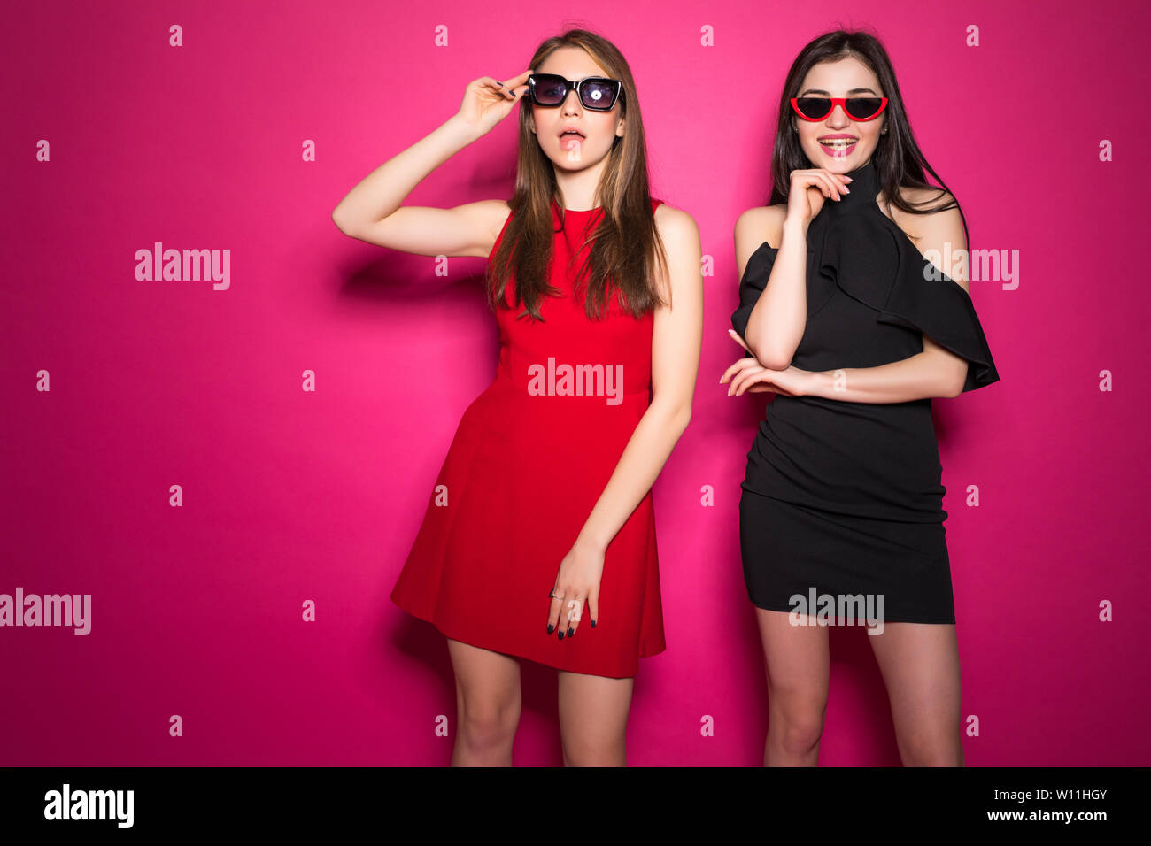 Deux jeunes filles vêtues de vêtements d'été isolé sur whispering secrets fond pourpre Banque D'Images