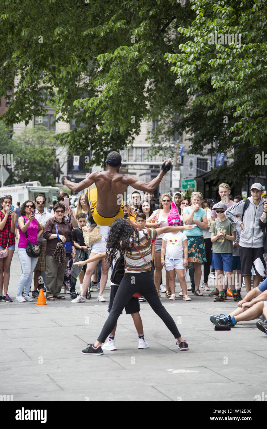 Acrobates de divertir une foule importante par City Hall Park le long de Park Row dans le lower Manhattan. Banque D'Images