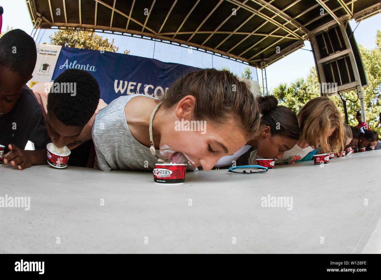 Les adolescents se font la concurrence dans une glace concours de manger sur la scène principale à l'Atlanta Ice Cream Festival à Piedmont Park le 28 juillet 2018 à Atlanta, GA. Banque D'Images