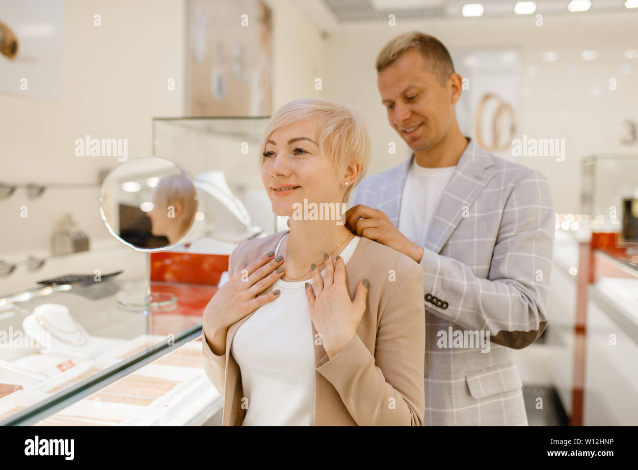 Love couple essayant sur la chaîne d'or en magasin de bijoux Banque D'Images