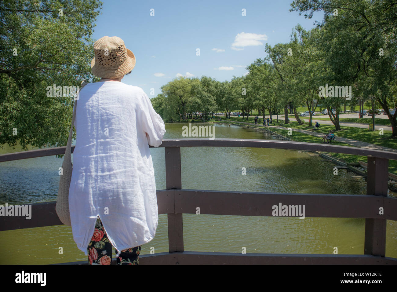 Femme mature, par derrière, en contemplant le lac depuis un pont. Banque D'Images